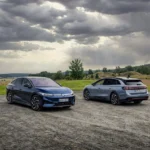 Volkswagen ID.7 berline bleue et ID.7 Tourer gris, deux futures voitures électriques VW stationnées face à un paysage scandinave